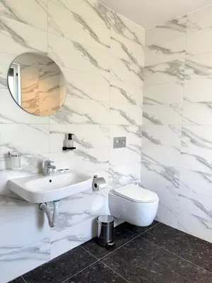 a white bathroom with a sink and a toilet at Hotel Mistral in Nesebar