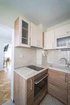 a kitchen with wooden cabinets and a sink at Hotel Mistral in Nesebar
