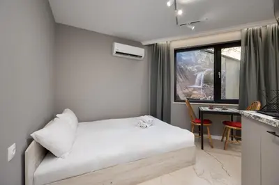 a bedroom with a bed and a table and a kitchen at Central Apartments with Patio Close to Sea in Varna City