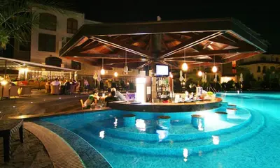 a swimming pool at night with a bar in the middle at Apartment Victoria Hotel & SPA Aheloy in Kableshkovo