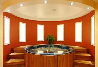 a hot tub in a room with orange walls at Apartment Victoria Hotel & SPA Aheloy in Kableshkovo