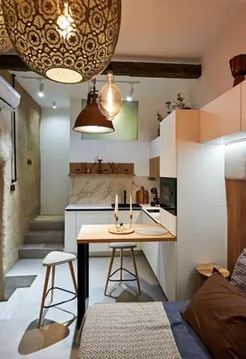 a small kitchen with a table and two stools at Studio in the Center of Burgas next to the See in Burgas City