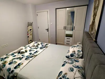a bedroom with a bed with blue flowers on it at Апартамент BLUE CREAM in Burgas City