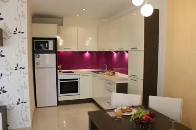 a kitchen with white cabinets and a table with a dining room at Vello Apartments in Byala
