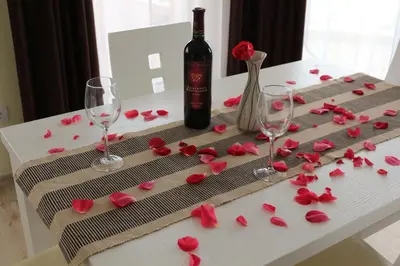 a table with roses and a bottle of wine and glasses at Vello Apartments in Byala