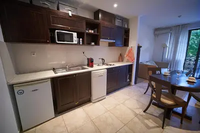 a kitchen with a sink and a table with a microwave at The Cliff Lux Apartment Obzor, Burgas, Bulgaria in Obzor