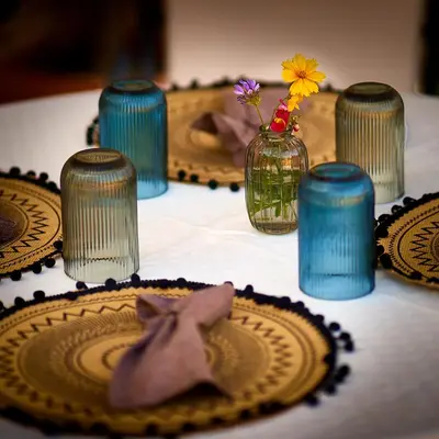 a table with plates and a vase with flowers on it at The Cliff Lux Apartment Obzor, Burgas, Bulgaria in Obzor