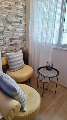 a living room with a table and a chair at Лазуро in Burgas City