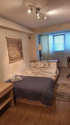 a bedroom with a large bed and a window at Лазуро in Burgas City