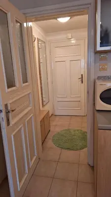 a kitchen with a white door and a green rug at Лазуро in Burgas City