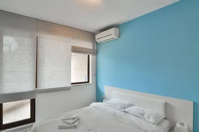 a bedroom with a white bed and a window at Central gem for 2 next to beach in Varna City