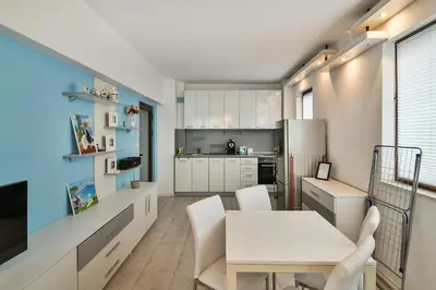 a kitchen with a white table and a white refrigerator at Central gem for 2 next to beach in Varna City