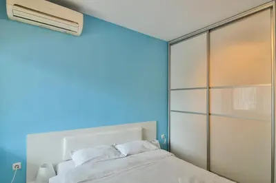 a bedroom with a white bed and a blue wall at Central gem for 2 next to beach in Varna City