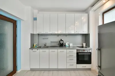 a kitchen with white cabinets and a stove top oven at Central gem for 2 next to beach in Varna City