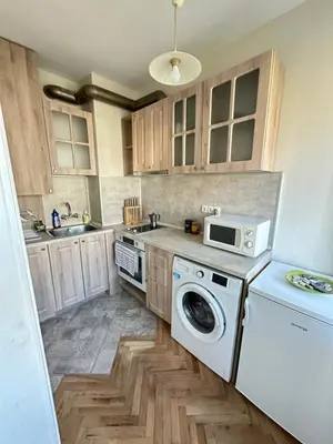 a kitchen with a washing machine and a microwave at Something In French in Burgas City