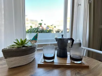 a tea kettle and two glasses on a table at Something In French in Burgas City