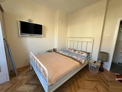 a bedroom with a white bed and a flat screen tv at Something In French in Burgas City