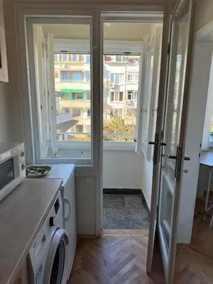 a kitchen with a washer and dryer and two windows at Something In French in Burgas City