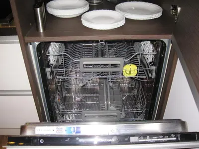 an open dishwasher with plates and dishes in it at Apartment Alegria in Varna City