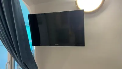 a flat screen tv hanging on a wall at Sunrise Sea Garden in Burgas City