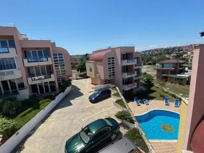 a car parked in a parking lot next to a pool at White Pearl Apartment Sozopol in Sozopol