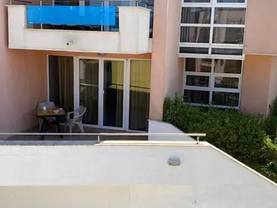 a building with a table and a chair in front of it at White Pearl Apartment Sozopol in Sozopol