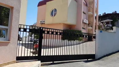 a black gate in front of a building at White Pearl Apartment Sozopol in Sozopol