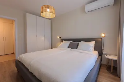 a bedroom with a large bed with white sheets at Zerini Apartment in Burgas City