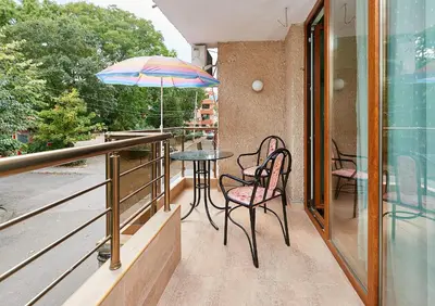a balcony with a table and chairs and an umbrella at Apartment Dora in Pomorie