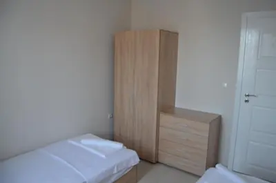 a bedroom with a bed and a wooden cabinet at Divela 3 Apartments in Nesebar
