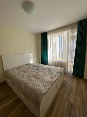 a bedroom with a large bed and green curtains at Burgas in Burgas City
