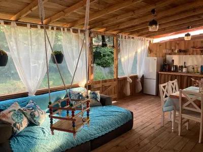 a living room with a swing in a house at Каравана Макси in Chernomorets