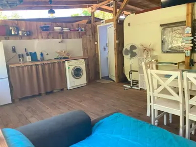 a living room with a washing machine and a kitchen at Каравана Макси in Chernomorets