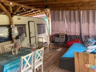 a room with a caravan with a bed and a table at Каравана Макси in Chernomorets