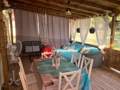 a living room with a table and a bed at Каравана Макси in Chernomorets