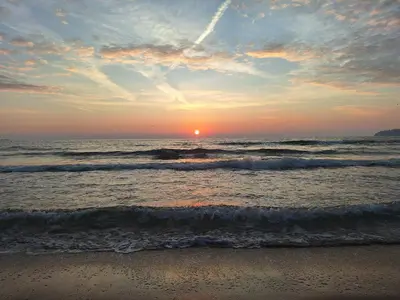 a sunset on the beach with the ocean at Small sea sunrise in Sveti Vlas