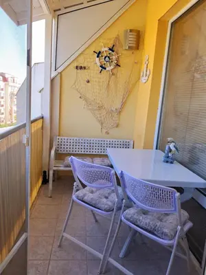 a table and chairs on a balcony with a map on the wall at Small sea sunrise in Sveti Vlas