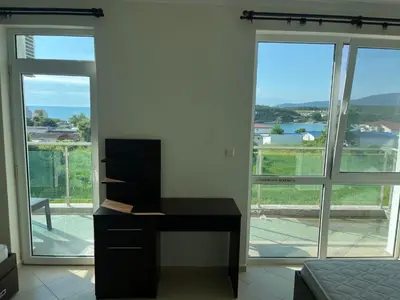 a bedroom with a desk in front of a large window at Вила Арапя in Tsarevo