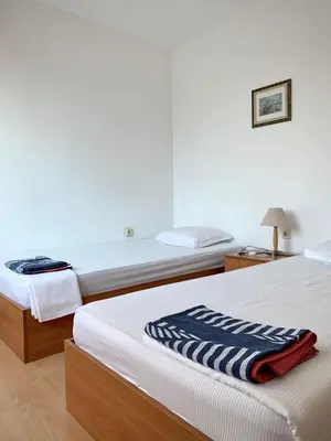 two beds in a hotel room with a blanket at Тедис хоум in Burgas City