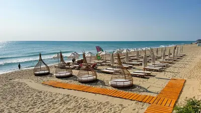 a group of chairs and umbrellas on a beach at La Boheme - Adults Only in Obzor