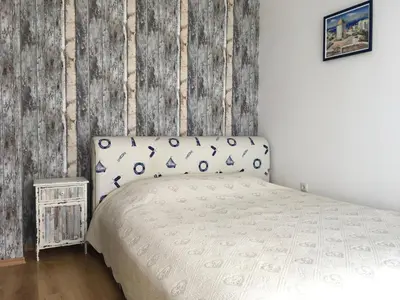 a bedroom with a bed and a wooden wall at HPManagement Byala Beach Residence Apartments in Byala