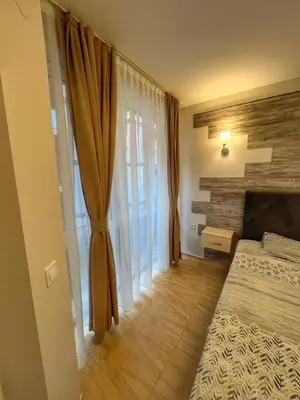 a bedroom with a bed and curtains and a fireplace at Paradise Dreams Studio in Sveti Vlas