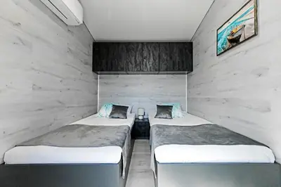 two twin beds in a room with a wall at Black Sea Villas Fichoza in Varna City