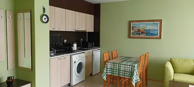 a kitchen with a washing machine and a table at Apartament Amelia in Sunny Beach