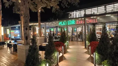 a restaurant at night with trees in front of it at Apartament Amelia in Sunny Beach
