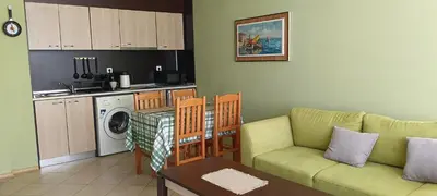 a living room with a couch and a kitchen at Apartament Amelia in Sunny Beach