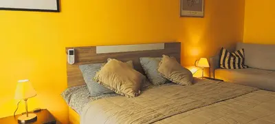 a bedroom with yellow walls and a bed with pillows at Apartament Amelia in Sunny Beach