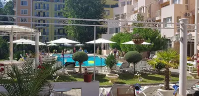 a swimming pool with chairs and umbrellas and a resort at Vanilla Garden Apartments in Sunny Beach