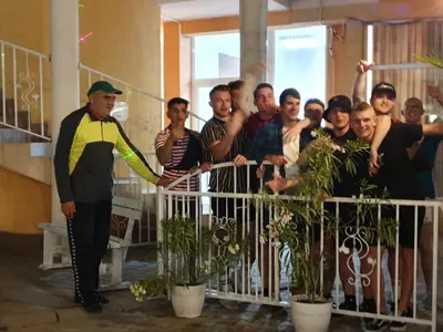 a man standing next to a group of people behind a fence at Vanilla Garden Apartments in Sunny Beach