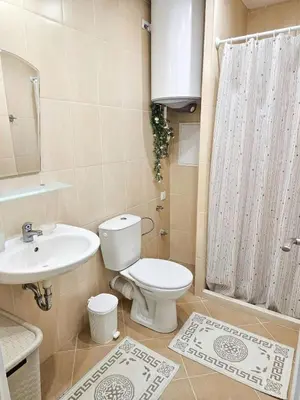 a bathroom with a toilet and a sink and a shower at FOUR SEASONS Beach Apartment in Pomorie